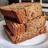 Healthy whole wheat banana bread sliced on a wooden board.