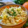 Bowl of homemade chicken noodle soup with fresh vegetables and herbs