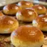 Freshly baked homemade dinner rolls on a wooden serving board