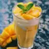 Bowl of homemade peach ice cream topped with fresh peach slices.