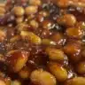 A delicious bowl of hot honey baked beans with a glossy glaze, perfect for barbecues