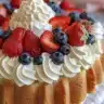Colorful patriotic berry dessert featuring strawberries, blueberries, and whipped cream.