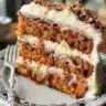 A slice of moist pineapple carrot cake topped with cream cheese frosting.