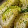 Plate of roasted cabbage drizzled with lemon herb dressing and garnished with herbs