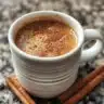 A cup of spiced coffee with aromatic spices and steam rising