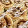 Apple Fritter Cinnamon Roll Bake showing a delicious golden-brown dessert with apple pieces.