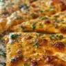 Baked cheddar parmesan crisps on a wooden platter with herbs