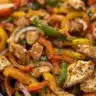Baked chicken fajitas served with colorful peppers and onions