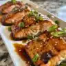 Baked Teriyaki Salmon fillets garnished with green onions on a plate