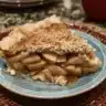 Caramel Apple Crisp baked in a cast-iron skillet topped with caramel sauce