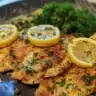 Delicious Chicken Piccata served with lemon and capers on a white plate