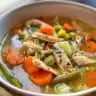 Bowl of delicious chicken vegetable soup with fresh veggies and chicken pieces