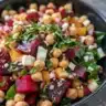 Chickpea beet feta salad with colorful vegetables in a bowl.