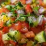 Chilled cucumber gazpacho served in a bowl garnished with herbs