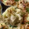 Bowl of creamy cauliflower soup topped with herbs and spices