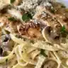 Creamy Chicken Marsala served over fettuccine pasta with herbs and mushrooms