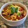 Bowl of creamy Chicken Taco Soup topped with cheese and cilantro