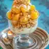 Creamy peach cobbler overnight oats served in a bowl with fresh peaches