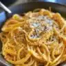 Creamy vegan pumpkin pasta served in a bowl with herbs on top