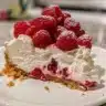 Creamy raspberry cheesecake bars garnished with fresh raspberries and mint.