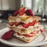 Delicious creamy strawberry cheesecake pancakes topped with fresh strawberries
