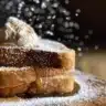 Plate of decadent stuffed French toast topped with berries and syrup