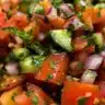 A bowl of easy gazpacho topped with fresh herbs and vegetables