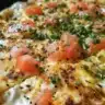 Flatbread topped with cottage cheese and herbs, served on a wooden board.