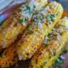 Delicious foil-wrapped grilled corn on the cob served at a summer barbecue.
