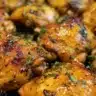 Golden crispy spiced chicken thighs garnished with herbs and spices