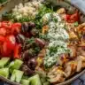Delicious Greek Chicken Bowls with fresh vegetables and herbs.