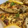 Plate of Greek-Style yogurt-marinated chicken garnished with herbs.