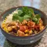Healthy chicken burrito casserole topped with fresh ingredients and cheese