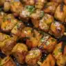 Honey Garlic Chicken Skewers served on a plate garnished with herbs