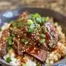 Korean BBQ Steak rice bowl with spicy cream sauce garnished with vegetables.