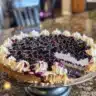 Slice of moist lemon blueberry cake topped with fresh blueberries and lemon zest