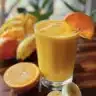 Mango orange banana cold buster smoothie in a glass, perfect for boosting immunity