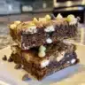 Moist chocolate banana zucchini bread slice on a wooden board.