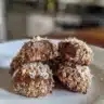 No bake chocolate coconut energy bites in a bowl with coconut flakes