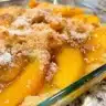 Delicious plant-based peach cobbler served warm with a scoop of vegan ice cream.