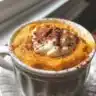 Fluffy pumpkin waffles topped with syrup and whipped cream on a plate