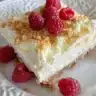Delicious Raspberry Lemon Cheesecake slice on a plate with fresh raspberries