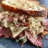 Delicious Reuben Sandwich with corned beef, Swiss cheese, and sauerkraut on rye bread.
