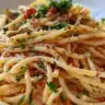 Delicious sardine pasta dish garnished with herbs and served in a bowl.