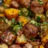 Sheet pan chicken sausage with colorful roasted vegetables dinner.
