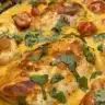Slow cooker creamy tomato basil chicken served on a plate with fresh herbs
