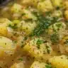 Bowl of creamy stovetop potato leek soup topped with herbs