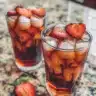 Strawberry-Infused Hibiscus Iced Tea served in a glass with fresh strawberries.