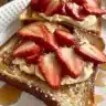Delicious Strawberry Stuffed French Toast topped with fresh strawberries and syrup