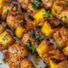 Delicious sweet, smoky, and spicy chicken skewers on a grill
